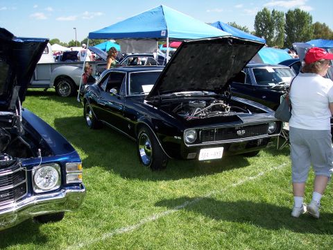 1972 Ford Ranchero - A black 1967 Chevrolet Camaro SS is displayed with its hood open at an outdoor car show.