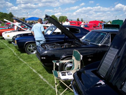 1972 Ford Ranchero - A line of cars are displayed on a grassy field under a partly cloudy sky at an outdoor car show.