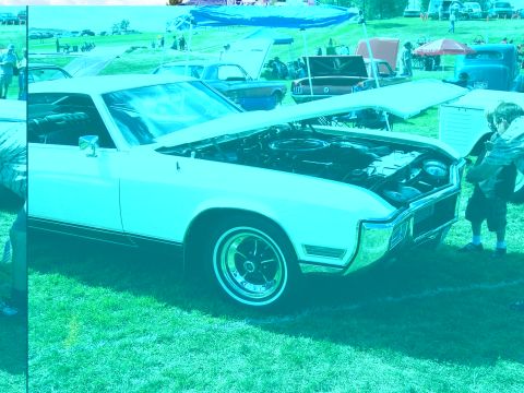 1972 Ford Ranchero - A 1971 Buick Riviera is displayed with its hood open at an outdoor car show.