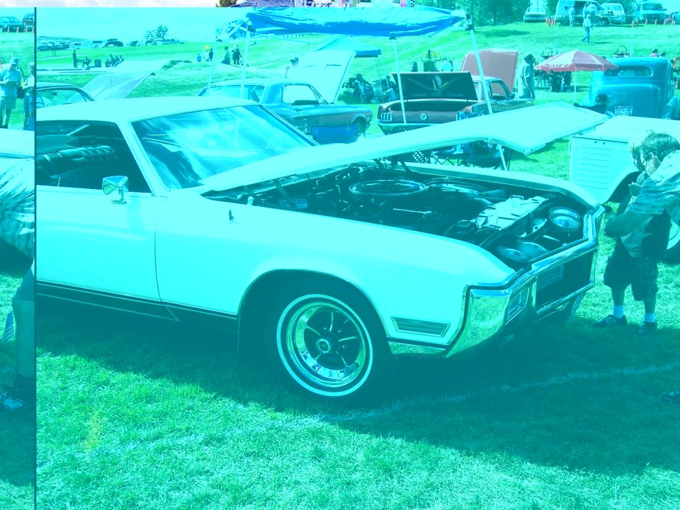 1971 Buick Riviera with hood open, parked on grass at an outdoor event