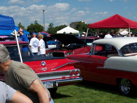 1972 Ford Ranchero - A sunny day at a car show features multiple vintage automobiles on display under tents and open sky.