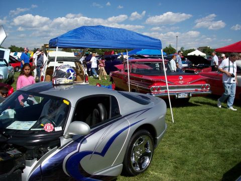 1972 Ford Ranchero - A silver sports car with custom blue flame graphics is on display at an outdoor car show.