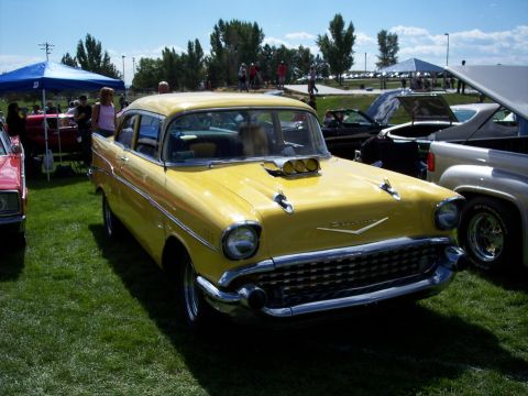 1972 Ford Ranchero - A yellow 1957 Chevrolet Bel Air sedan is displayed at an outdoor car show.