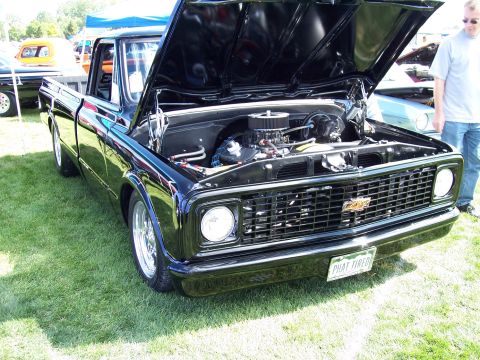 1972 Ford Ranchero - A black pickup truck is displayed with its hood open, revealing the engine and custom modifications.