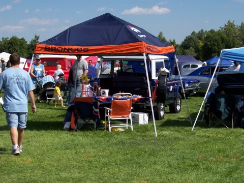 1972 Ford Ranchero - A blue Ford Bronco is displayed at an outdoor event with other vehicles and people.