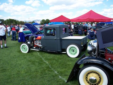 1972 Ford Ranchero - A custom hot rod pickup truck is displayed on a grassy field at an outdoor car show.