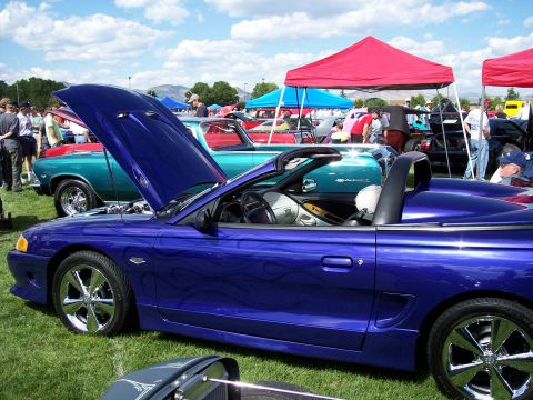 1972 Ford Ranchero - A blue convertible with custom flame decals is displayed with its hood open at an outdoor car show.