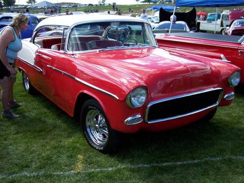 1972 Ford Ranchero - A woman looks at a red and white classic car at an outdoor car show.