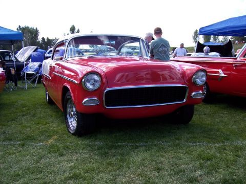 1972 Ford Ranchero - A classic red Chevrolet is displayed at an outdoor event, with other vehicles and tents visible.