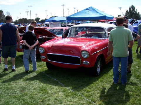 1972 Ford Ranchero - A red and white two-tone car is displayed on a grassy field at an outdoor car show.