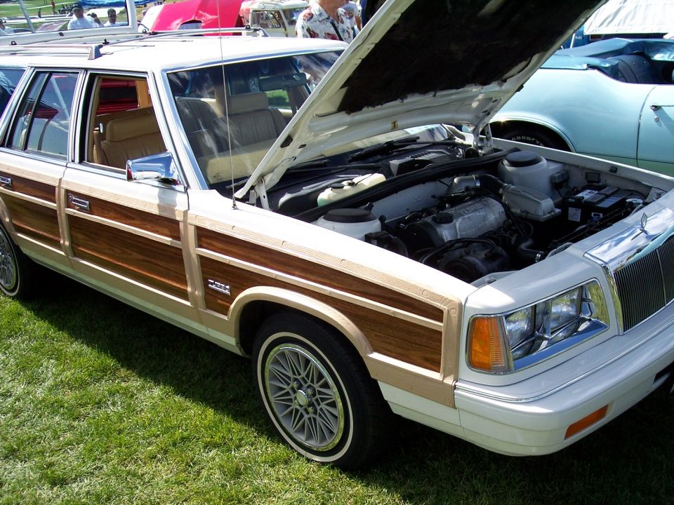 Woody station wagon with hood open, showing engine. Another car is visible to the right