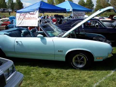1972 Ford Ranchero - A light blue 1970 Oldsmobile 442 convertible is displayed with its hood open at an outdoor car show.