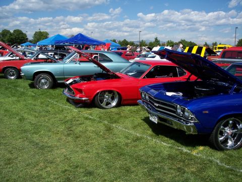 1972 Ford Ranchero - A lineup of classic cars with their hoods open at an outdoor car show under a partly cloudy sky.