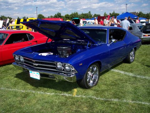 1972 Ford Ranchero - A blue 1969 Chevrolet Chevelle SS is displayed with its hood open at an outdoor car show.
