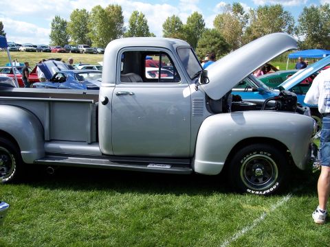 1972 Ford Ranchero - A classic silver pickup truck is displayed with its hood open at an outdoor car show.
