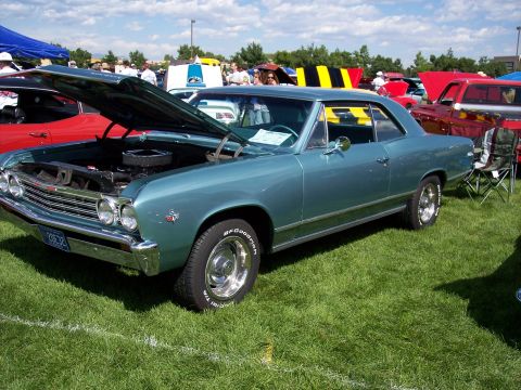 1972 Ford Ranchero - A teal 1966 Chevrolet Chevelle coupe is displayed with its hood open at an outdoor car show.