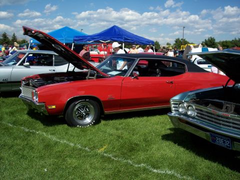 1972 Ford Ranchero - A red coupe, possibly a 1970 model, is displayed with its hood open at a car show.
