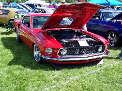 1972 Ford Ranchero - A red 1969 Ford Mustang coupe is displayed with its hood open at an outdoor car show.