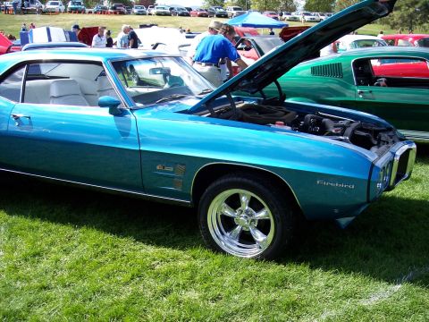 1972 Ford Ranchero - A bright blue 1969 Firebird coupe is displayed with its hood open at an outdoor car show.