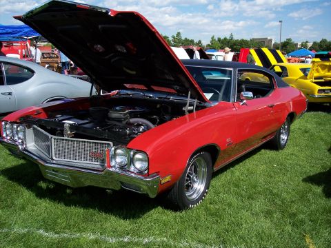 1972 Ford Ranchero - A red 1970 Buick GSX is displayed with its hood open at an outdoor car show.