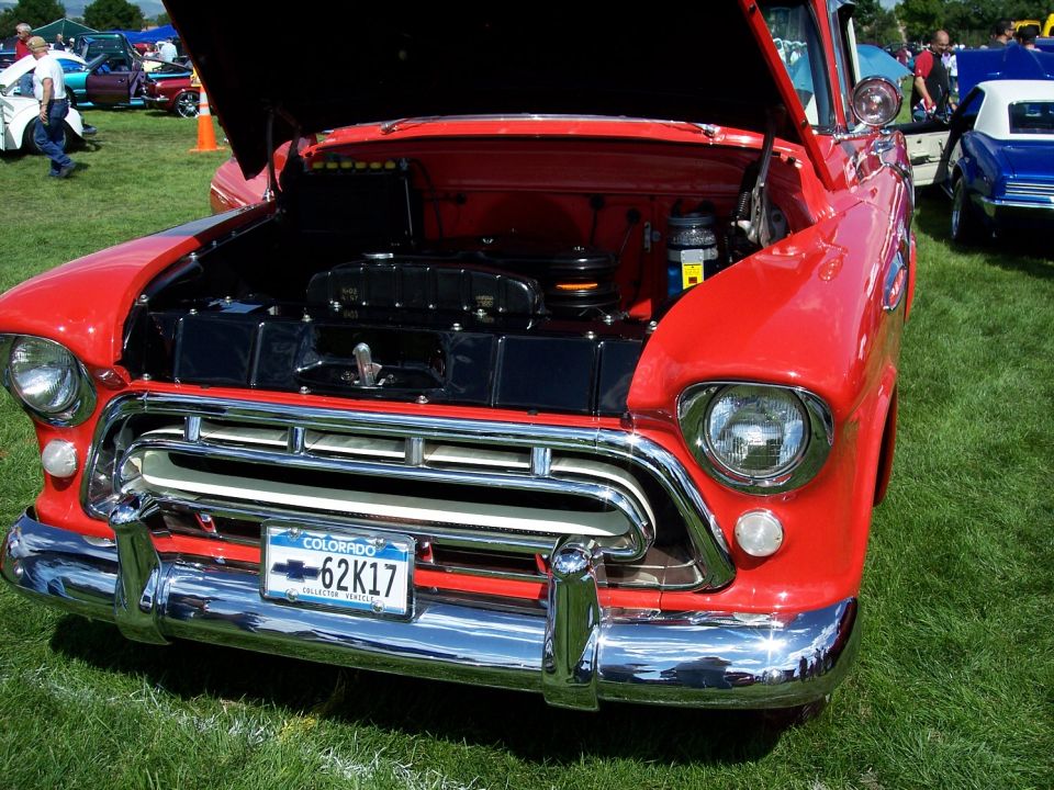 Red 1955 Chevrolet pickup truck front end, hood open showing engine. Colorado license plate 62K17