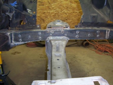 1964 Ford Fairlane - Close-up of a car's frame undergoing repair work, showing welded joints and mounting points.