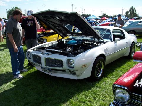 1972 Ford Ranchero - White 1973 Pontiac Firebird Trans Am at an outdoor car show, hood raised to display the engine.