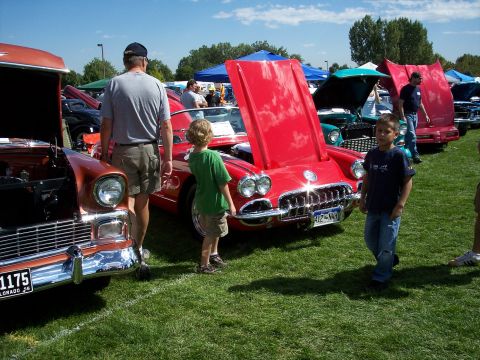 1972 Ford Ranchero - A car show features several classic vehicles on display, with attendees admiring them on a sunny day.