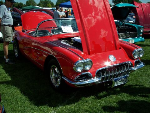 1972 Ford Ranchero - A bright red 1959 Chevrolet Corvette convertible is displayed with its hood open at an outdoor car show.