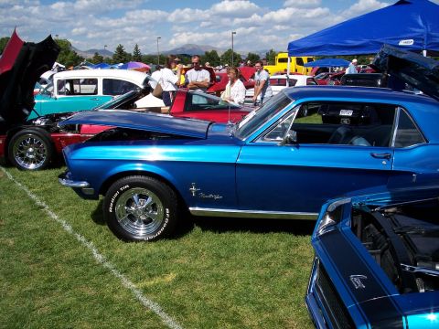 1972 Ford Ranchero - A blue 1967 Ford Mustang coupe is displayed at an outdoor car show with other vehicles.