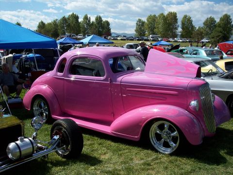 1972 Ford Ranchero - Custom pink hot rod coupe with flame graphics displayed at an outdoor car show.