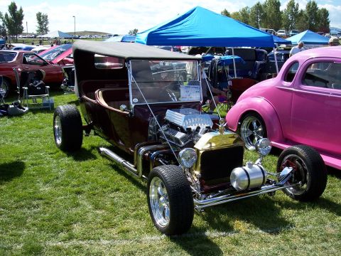 1972 Ford Ranchero - A custom hot rod with a powerful engine is displayed at an outdoor car show.