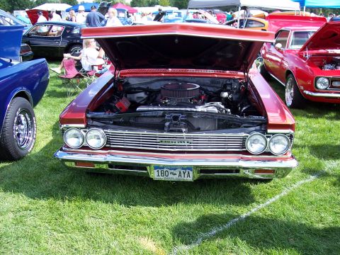 1972 Ford Ranchero - A classic red Chevrolet is displayed with its hood open at an outdoor car show.