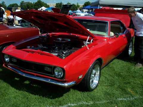 1972 Ford Ranchero - A bright red classic car is displayed with its hood open, revealing the engine, at an outdoor event.