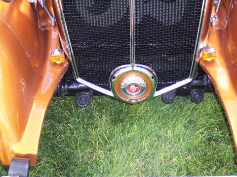 1972 Ford Ranchero - A close-up view of the front grille and fender of a classic car, set against a backdrop of green grass.