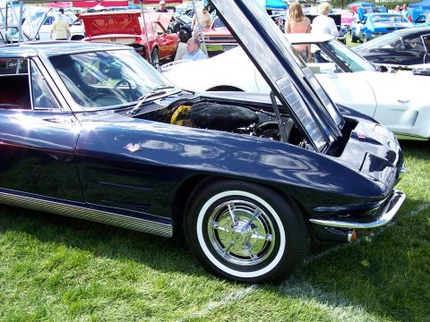 1972 Ford Ranchero - A 1965 Chevrolet Corvette Sting Ray is displayed with its hood open at an outdoor car show.