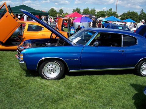 1972 Ford Ranchero - A blue muscle car, identified as a Malibu 350, is displayed with its hood open at an outdoor car show.