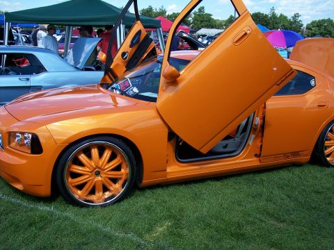 1972 Ford Ranchero - A custom orange Dodge Charger with its doors open, displayed at an outdoor event with other vehicles present.