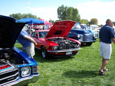 1972 Ford Ranchero - A red 1970 Ford Mustang is displayed with its hood up at an outdoor car show.