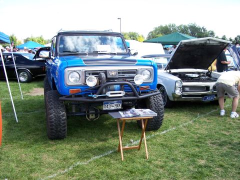 1972 Ford Ranchero - A lifted blue off-road vehicle is parked on grass, with other cars visible in the background.