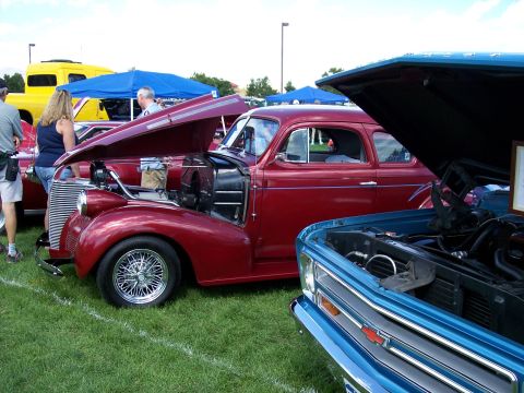 1972 Ford Ranchero - Two vintage vehicles are displayed with their engines visible at a car show event.