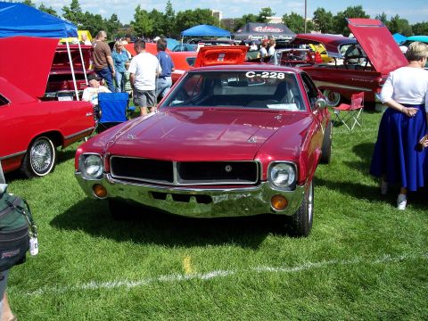 1972 Ford Ranchero - A red 1970 AMC Javelin is displayed at an outdoor car show with other vehicles present.