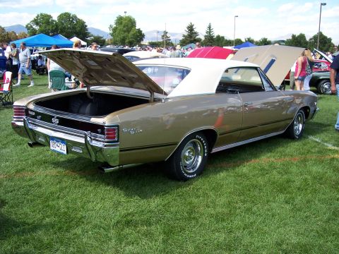 1972 Ford Ranchero - A gold 1967 Chevrolet Chevelle SS convertible is displayed with its trunk open at an outdoor car show.