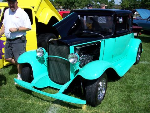 1972 Ford Ranchero - A custom coupe hot rod with a two-tone paint scheme is displayed at an outdoor event.