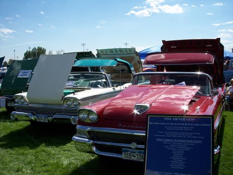 1972 Ford Ranchero - A red 1958 Ford Fairlane 500 Skyliner retractable hardtop is displayed with its hood open at an outdoor car show.