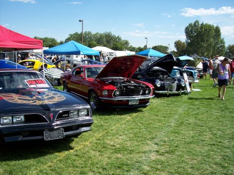 1972 Ford Ranchero - Cars are displayed on a sunny day at an outdoor event, with people milling around and tents providing shade.