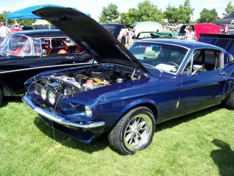 1972 Ford Ranchero - A blue coupe with its hood open, parked on grass at an outdoor event.