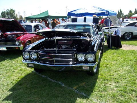 1972 Ford Ranchero - A black 1970s muscle car is displayed with its hood open at an outdoor car show.