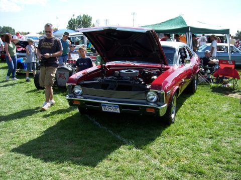 1972 Ford Ranchero - A red coupe is displayed with its hood up at an outdoor car show, with other vehicles and attendees around.