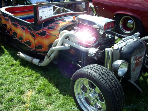 1972 Ford Ranchero - A custom hot rod with a powerful engine and flame graphics sits on display at an outdoor event.